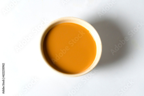 Fresh milk tea or indian karak chai in payali or masala tea in clay cup on white background. top view