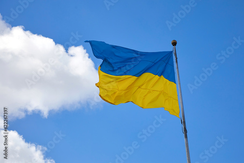 Ukraine flag, national symbol fluttering in blue sky.