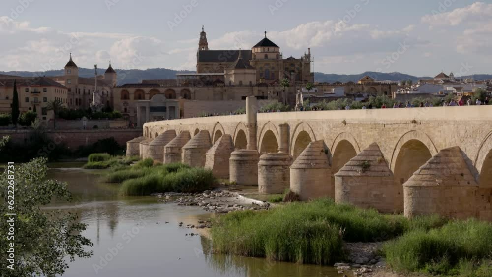 a high angle afternoon view of the ancient roman bridge and the mosque-cathedral of cordoba,spain a high angle afternoon view of the ancient roman bridge and the mosque-cathedral of cordoba,spain