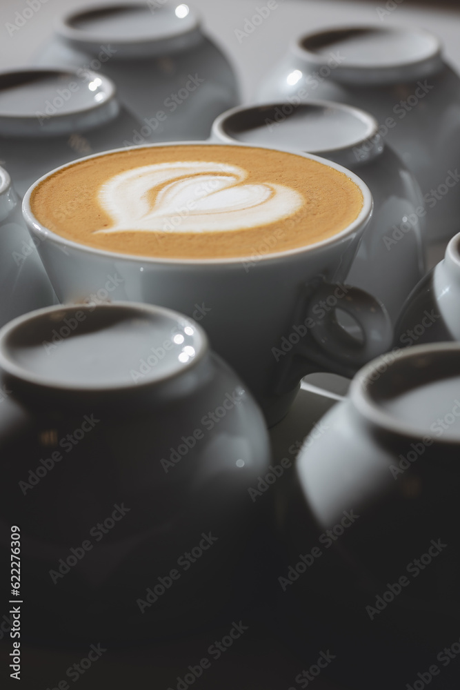 Bright photo for coffeeshop stories advertising. Logo heart on alone coffee latte or cappuccino in white cup background, top view Bright photo for coffeeshop stories advertising. Logo heart on alone coffee latte or cappuccino in white cup background, top view