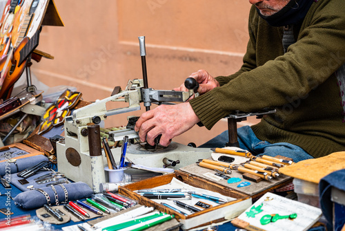 Fotografie Elderly engraver at work on a street bench