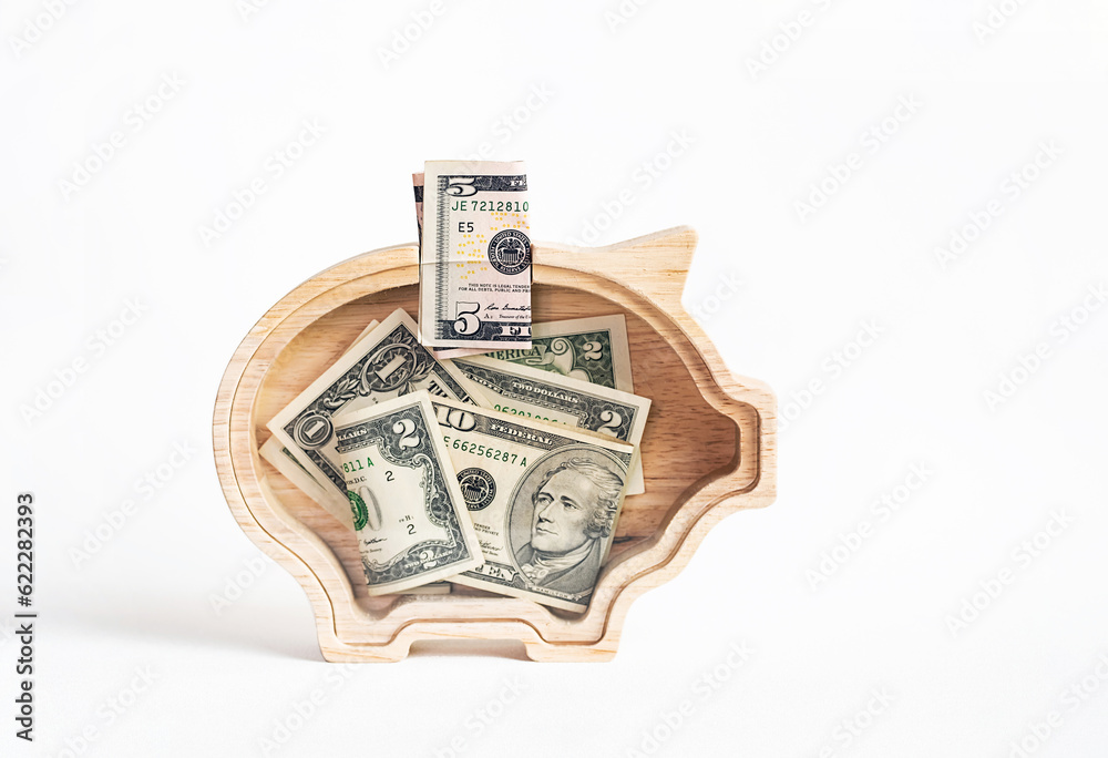 US dollars currency in piggy bank. Saving money. US dollars currency in piggy bank. Saving money.