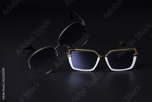 Close-up of two sunglasses on a black background. Vision protection concept.
