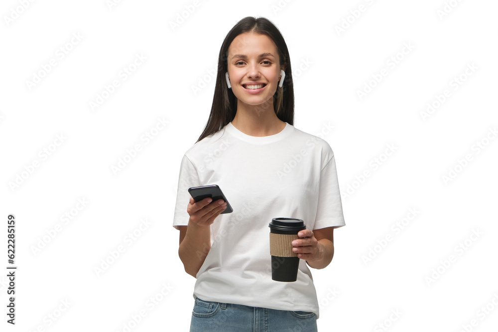 Woman looking at camera while holding phone in one hand and coffee cup in other Woman looking at camera while holding phone in one hand and coffee cup in other
