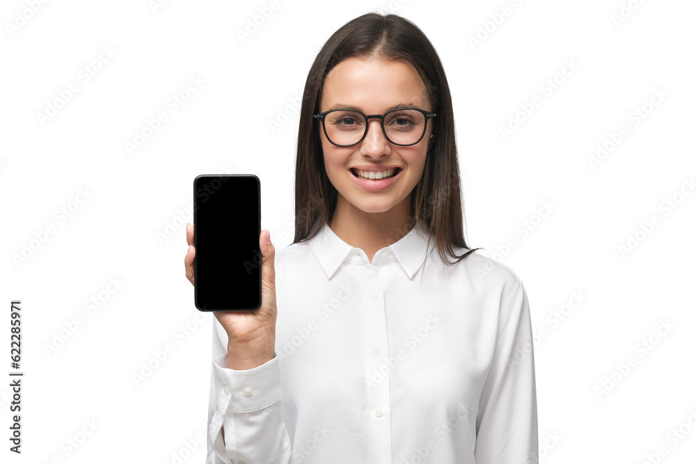 Young business woman wearing formal office shirt and big eyeglasses showing phone with blank screen and presenting it