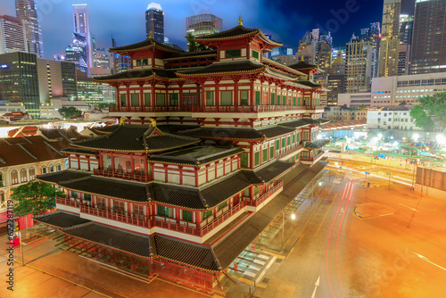 Buddha Tooth Relic Temple in Singapore's Chinatown district transforms into a captivating spectacle at night, radiating gentle golden light. Its intricate architectural elements exude a heavenly charm