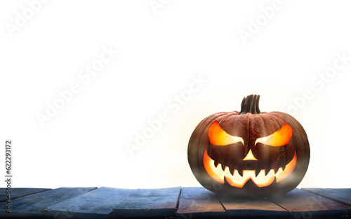 Obraz na płótnie A single lit Jack-o-Lantern, halloween pumpkin lantern on a wooden product display table with an isolated transparent background. w salonie