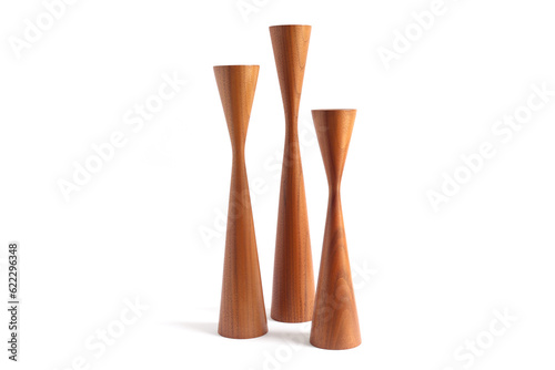 Studio shot of three vintage Danish mid-century teak candleholders, isolated on a white background.