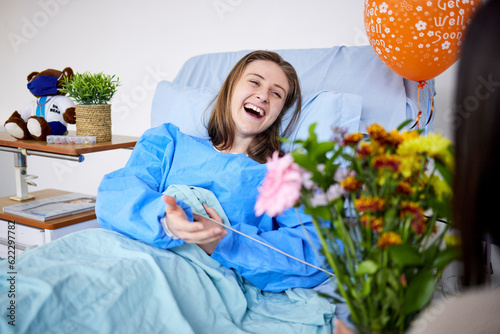 Fotografía Sick, hospital patient and visitor with flowers at bed with a woman in recovery with support