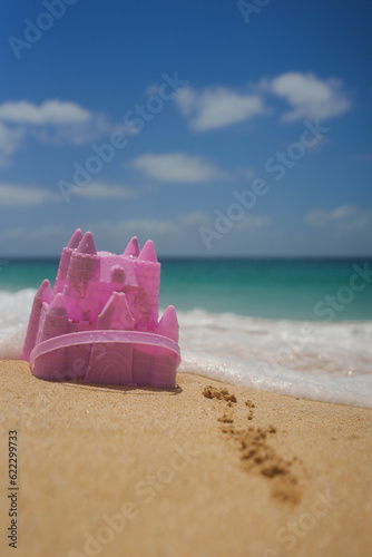 Pink beach toy castle in the sand