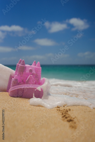 Pink beach toy castle in the sand