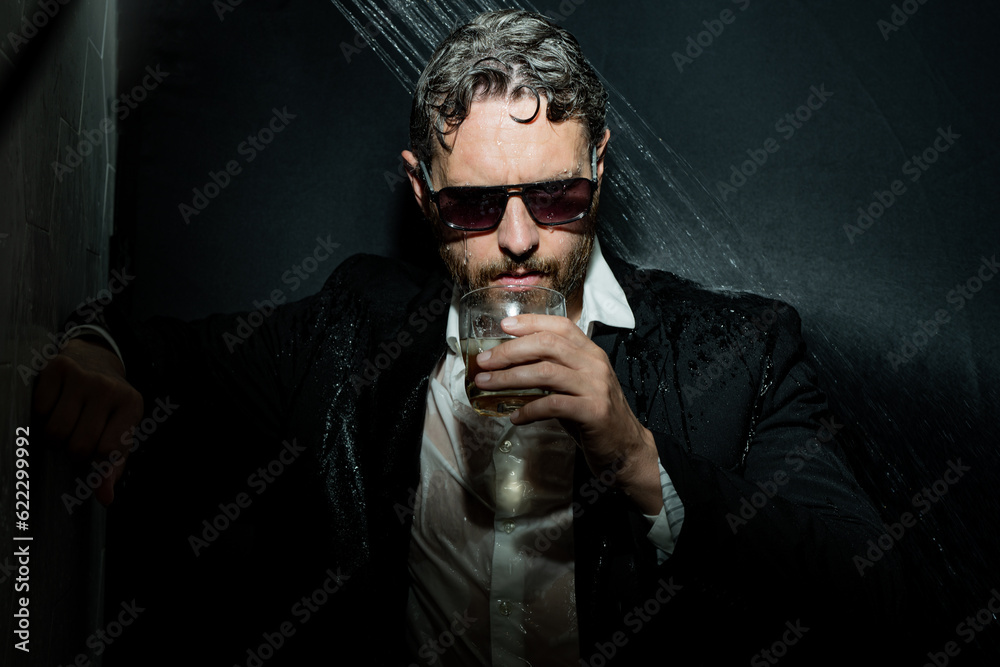 Drunk business man. Disheveled man in suit in bathroom after night party. Man drinking a whiskey