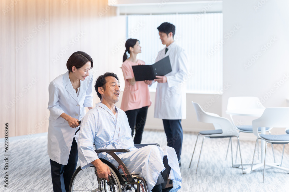 病院で車椅子に乗った入院患者と話す医者