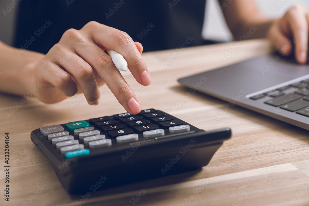 Hand using calculator to calculate income expenses and plans for spending money on home. Hand using calculator to calculate income expenses and plans for spending money on home.