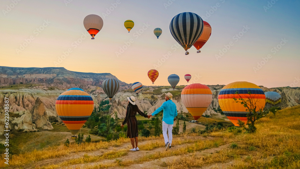 © Fokke Baarssen - Kapadokya Cappadocia Turkey, a happy young couple during sunrise watching the hot air balloons of Kapadokya Cappadocia Turkey during vacation