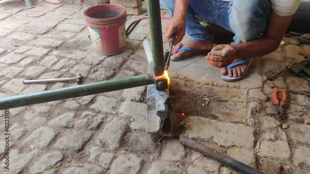 Metal welder working with arc welding machine to weld iron pipes Metal welder working with arc welding machine to weld iron pipes
