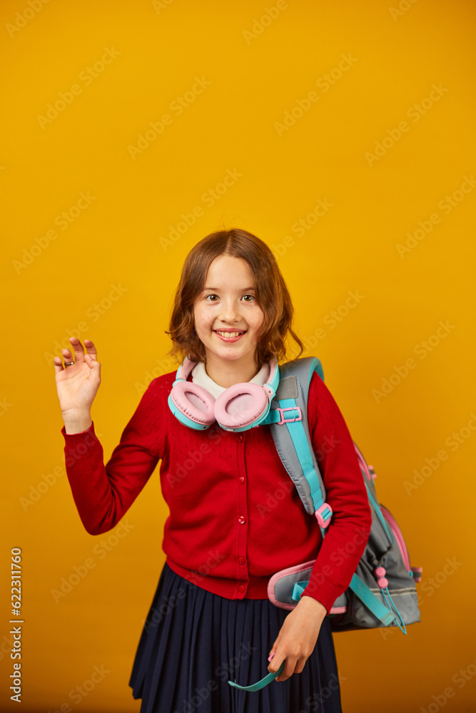 Stylish school teenage girl in headphone with a backpack on her shoulder Stylish school teenage girl in headphone with a backpack on her shoulder