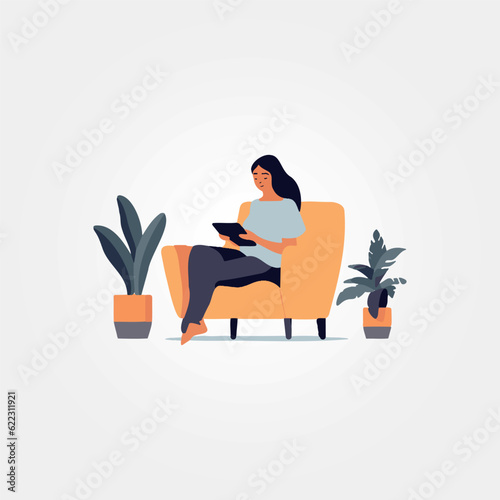woman sitting in armchair using tablet