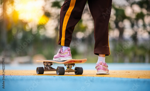 Portrait of happy asia girl pose smiling at camera while riding on skateboard in public childrean park is extheam sport relaxing on holiday . photo