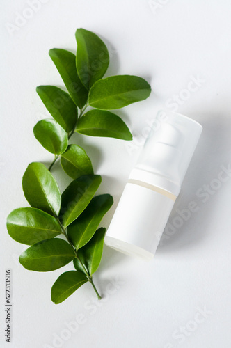 leaves and cosmetic container on white