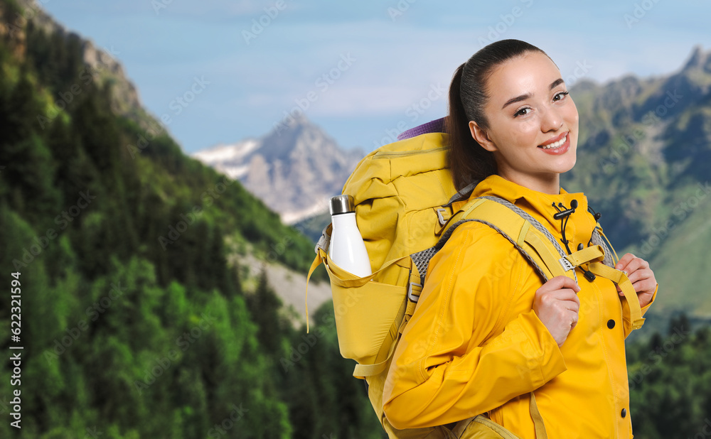 Happy tourist with yellow backpack in mountains