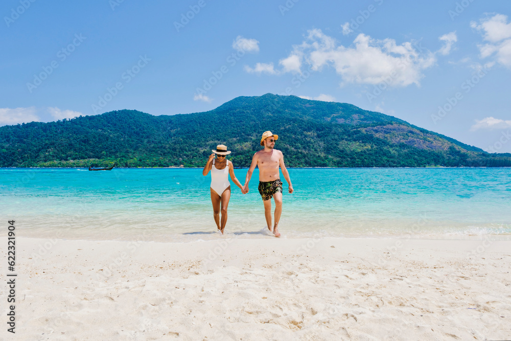 Couple of men and women on the beach of Koh Lipe Island Thailand, a tropical Island with a blue ocean and white soft sand. Ko Lipe Island Thailand