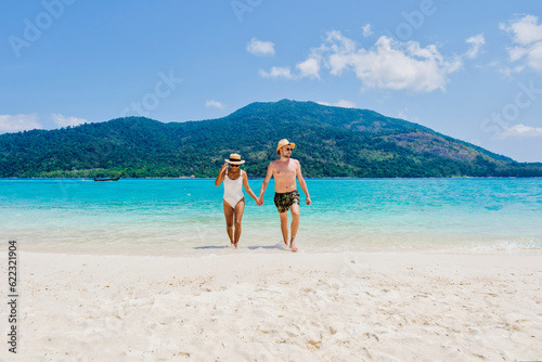 Couple of men and women on the beach of Koh Lipe Island Thailand, a tropical Island with a blue ocean and white soft sand. Ko Lipe Island Thailand