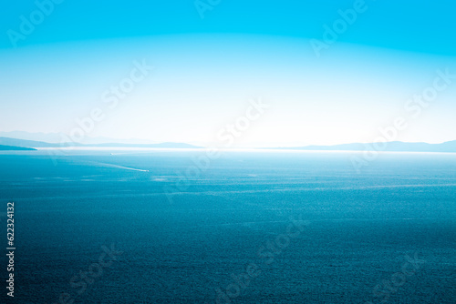 Beautiful Blue Sea and Sky. Islands in Haze on the Horizon. Aerial View. Summer Seascape with Clear Water. Serene Ocean and Tranquility Concept. Copy Space Background. Toned Photo. © Designpics