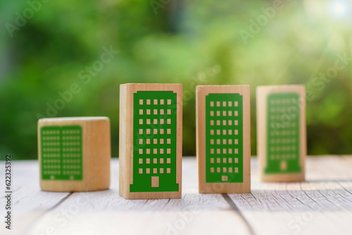 Green building symbols on wooden cubes on a wood table and natural background.LEED certification. Leadership in Energy and Environmental Design. Sustainable. Green and eco building concept.