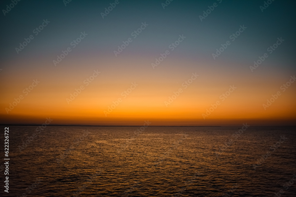 Sunrise sunset orange purple blue pink skies over ocean sea Sunrise sunset orange purple blue pink skies over ocean sea