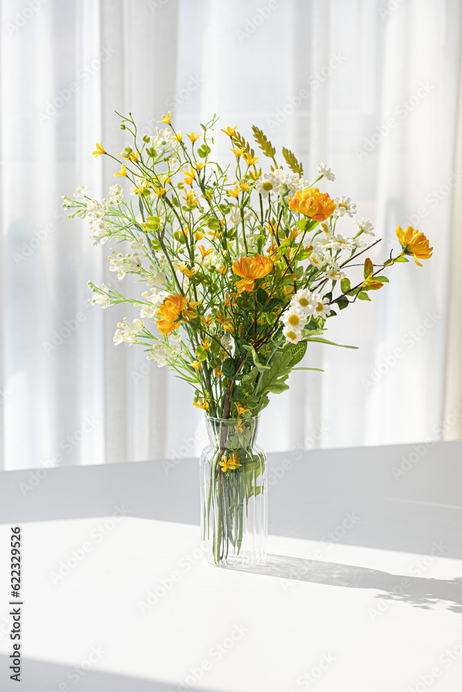 A small flower bouquet in a transparent vase A small flower bouquet in a transparent vase
