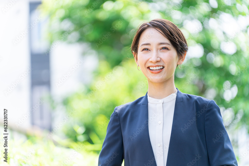 屋外にいるビジネスウーマン(新緑・自然・女性) 屋外にいるビジネスウーマン(新緑・自然・女性)