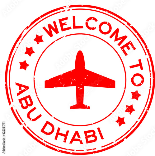 Grunge red welcome to abu dhabi with airplane icon round rubber seal stamp on white background