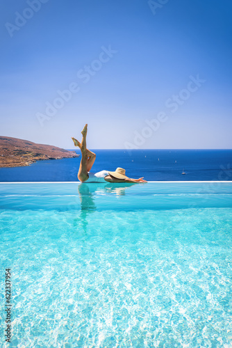 Sticker A attractive woman in a white swimsuit is relaxing at a infinity swimming pool d