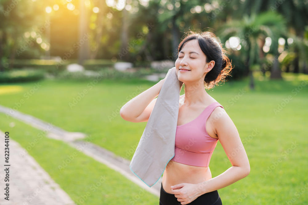 Fototapeta premium Fit 30s young asian woman enjoying a morning run in the park. This photo is sure to inspire others to get active and live a healthy lifestyle.
