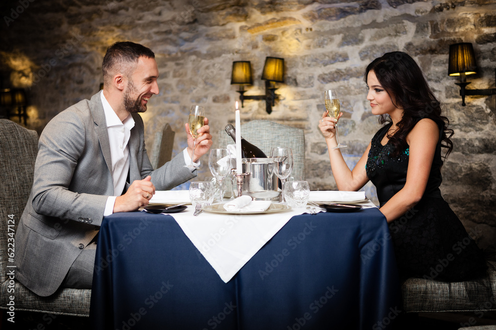 Couple with champange glasses dating and toasting in restaurant Couple with champange glasses dating and toasting in restaurant
