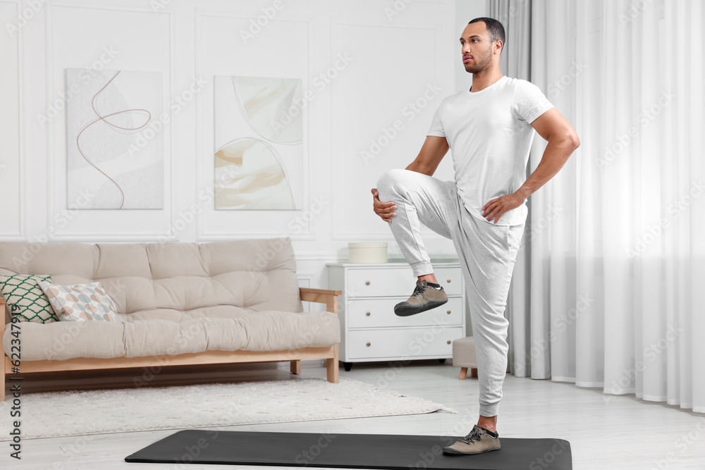 Man doing morning exercise on fitness mat at home Man doing morning exercise on fitness mat at home