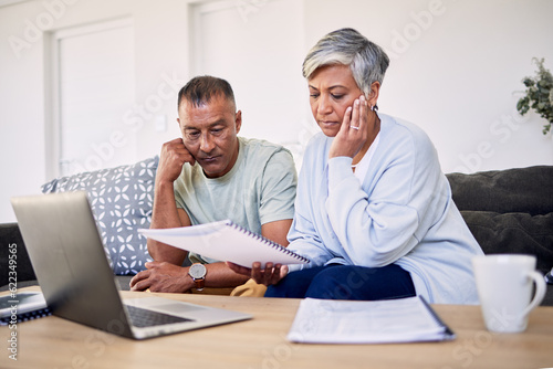 Senior couple, tax documents and stress with laptop in living room for planning, thinking and budget. Elderly man, woman and paperwork for financial compliance, anxiety or debt in retirement on sofa