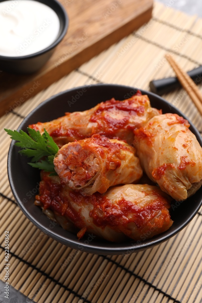 Fototapeta premium Delicious stuffed cabbage rolls cooked with homemade tomato sauce on table, closeup