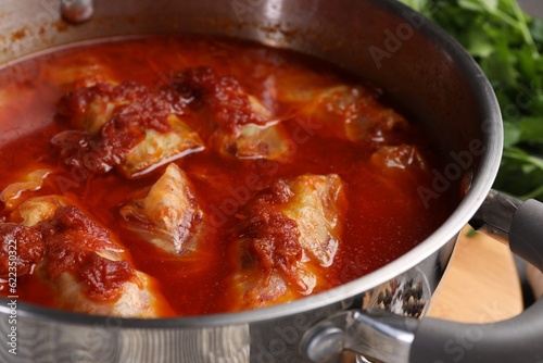 Delicious stuffed cabbage rolls cooked with homemade tomato sauce in pot, closeup