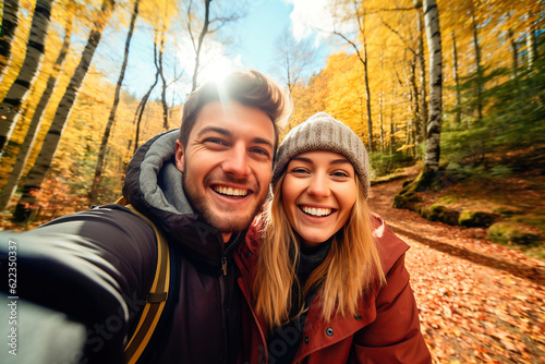 Canvas Print Attractive couple taking a selfie in a forest in autumn
