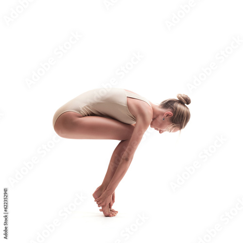 young beautiful dancer in beige swimsuit posing on isolated white studio background