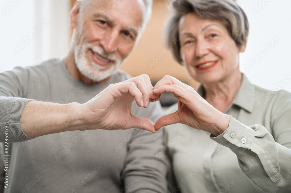 Mature couple showing heart gesture make love sign with hands Mature couple showing heart gesture make love sign with hands