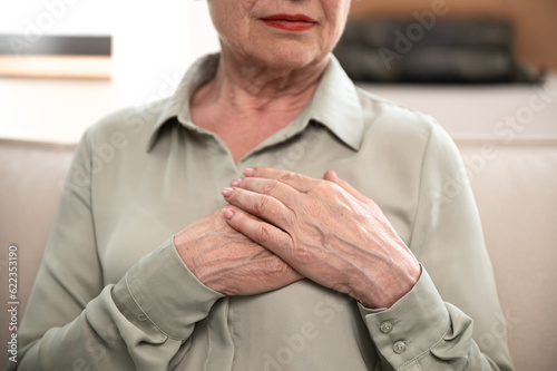 Mature elderly woman folded hand on chest