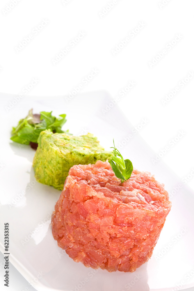 Delicious salmon tartare with fresh salad on white tray isolated on white background. Healthy seafood eating. Delicious salmon tartare with fresh salad on white tray isolated on white background. Healthy seafood eating.