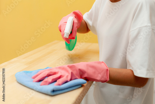 cleaning holding cleaning equipment Yellow background. housewife holding cleaning equipment.