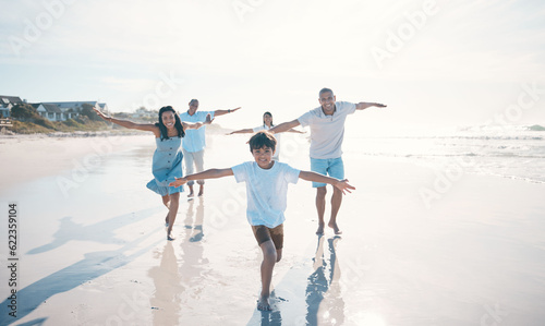 Fly, beach and happy family running or playing together at the sea or ocean bonding for love, care and happiness. Summer, sun and parents with children or kids and grandparents on holiday for freedom