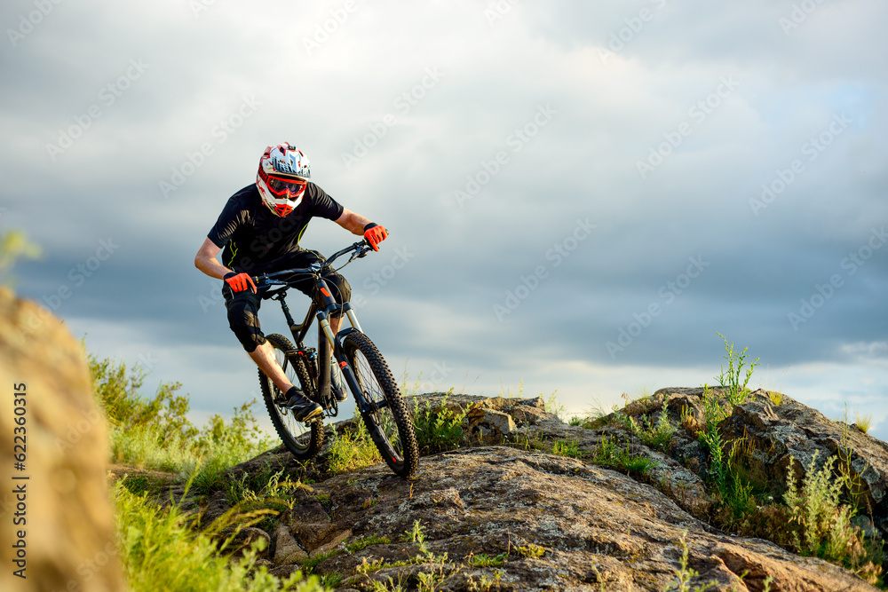 Professional Cyclist Riding the Bike on the Rocky Trail. Extreme Sport Concept. Professional Cyclist Riding the Bike on the Rocky Trail. Extreme Sport Concept.