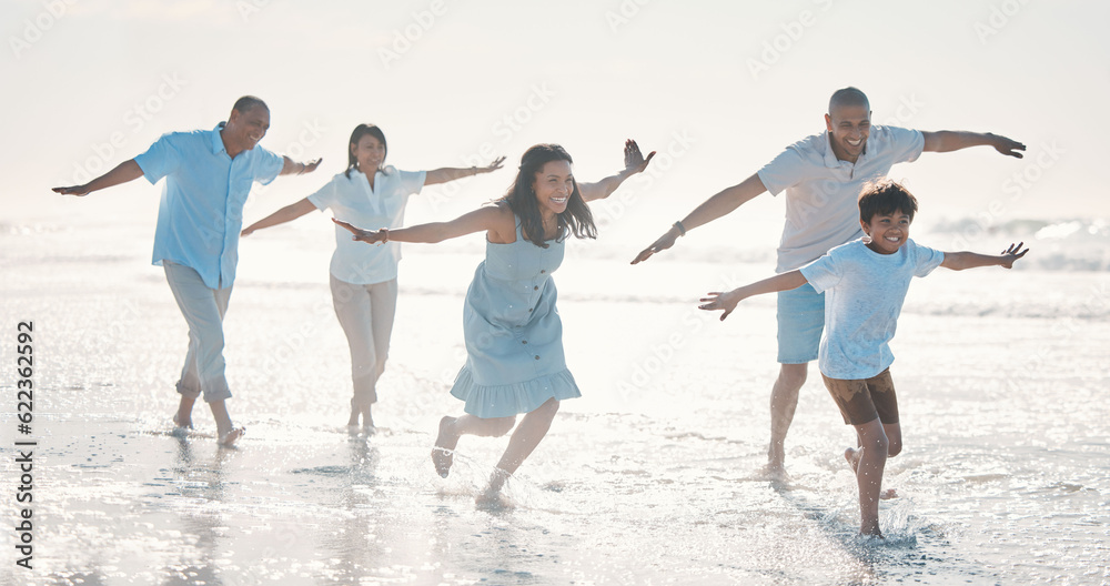 Travel, beach and happy family running together at the sea or ocean bonding for love, care and happiness. Summer, sun and parents with children or kids and grandparents on a holiday for freedom