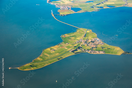 Aerial image of the Dutch island Marken in Noord Holland. Green fields and blue water of the IJsselmeer with sailboats photo